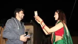 Karwa Chauth 2026 in Udaipur: Married woman offering arghya and looking at moon through chalni with diya