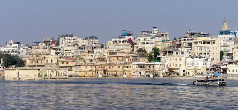 Lake Pichola and Fateh Sagar boating guide: Tourist motor boats sailing on Lake Pichola with Aravalli hills in Udaipur